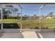 A view from the patio featuring a serene pond surrounded by lush greenery and well-maintained homes at 4951 Summertree Rd, Venice, FL 34293