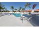 Community pool with tables, chairs and palm trees in a beautiful fenced-in area at 4951 Summertree Rd, Venice, FL 34293