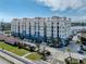 Upscale condo building featuring covered balconies, a red tile roof, lush landscaping, and a private marina at 501 Tamiami N Trl # 502, Venice, FL 34285