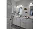 Bathroom featuring a dual vanity and mirrors with decorative fish artwork at 530 Walnut Cir, Venice, FL 34285