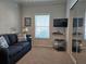 Bedroom featuring a loveseat with a side table and lamp, carpeted floors, and mounted television at 530 Walnut Cir, Venice, FL 34285