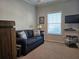 Bedroom featuring a loveseat with a side table and lamp, carpeted floors, and mounted television at 530 Walnut Cir, Venice, FL 34285