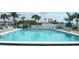 Large community pool with clear blue water, surrounded by lounge chairs and umbrellas at 530 Walnut Cir, Venice, FL 34285