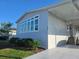 Home exterior with side porch, large windows, trimmed green bushes, and concrete driveway at 530 Walnut Cir, Venice, FL 34285