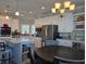 Modern eat-in kitchen featuring white cabinets, stainless steel appliances, and stylish lighting fixtures at 530 Walnut Cir, Venice, FL 34285