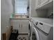 Well-lit laundry room features modern washer and dryer with lots of cabinets at 530 Walnut Cir, Venice, FL 34285