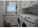 Bright laundry room features modern washer and dryer with lots of cabinets at 530 Walnut Cir, Venice, FL 34285