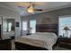 Cozy main bedroom with a ceiling fan, closet, and natural light from the windows at 530 Walnut Cir, Venice, FL 34285