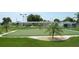 Enjoy the community putting green framed with palm trees and a crushed stone border at 530 Walnut Cir, Venice, FL 34285