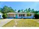 Charming single-story home with a manicured front lawn, a blue front door, and an attached garage at 5527 20Th W St, Bradenton, FL 34207