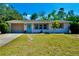 Charming single-story home with a well-manicured lawn, attached garage, and welcoming blue door at 5527 20Th W St, Bradenton, FL 34207