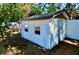 A small shed sits in a grassy yard, protected by a tall fence and mature shade trees at 5527 20Th W St, Bradenton, FL 34207