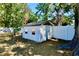 A small shed sits in a grassy yard, protected by a tall fence and mature shade trees at 5527 20Th W St, Bradenton, FL 34207