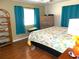 King-size bed, dresser, teal curtains, and wood floors in bedroom at 562 Longwood Dr, Venice, FL 34285