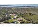 A bird's eye view reveals a sprawling residence, nearby pond, mature landscaping, and the water beyond at 5694 Hale Rd, Venice, FL 34293