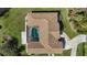 Overhead view of home with pool, screened lanai, tile roof, landscaping, and paved driveway at 5694 Hale Rd, Venice, FL 34293