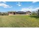 A beautifully landscaped backyard features a screened in porch and lush green grass at 5694 Hale Rd, Venice, FL 34293