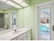 Bathroom with granite counter and large mirror with pool view at 5694 Hale Rd, Venice, FL 34293