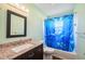 Bathroom with granite vanity, decorative mirror and a dolphin-themed shower curtain at 5694 Hale Rd, Venice, FL 34293