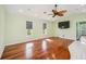 Bright living room with hardwood floors, ceiling fan, and large windows for natural light at 5694 Hale Rd, Venice, FL 34293