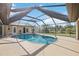 Screened-in pool, patio area with a view of the backyard and tropical landscaping at 5694 Hale Rd, Venice, FL 34293