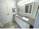 Bathroom featuring gray wood floors and a spacious double vanity with a granite countertop at 590 Portside Dr, North Port, FL 34287