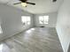 Bedroom with ceiling fan, neutral wall paint, wood look flooring and several windows at 590 Portside Dr, North Port, FL 34287