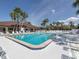 Exterior view of a luxurious pool featuring palm trees and a lounging area at 590 Portside Dr, North Port, FL 34287