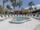 Exterior view of community hot tub surrounded by sun chairs and palm trees at 590 Portside Dr, North Port, FL 34287