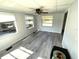 Bright living room featuring gray wood floors, neutral white walls and a ceiling fan at 590 Portside Dr, North Port, FL 34287