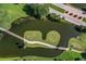 Aerial view of a well-manicured golf course with water features and lush greenery at 595 Back Nine Dr, Venice, FL 34285