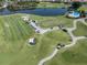 Expansive aerial view of the golf course with ponds, manicured fairways and golf carts at 595 Back Nine Dr, Venice, FL 34285