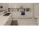 All-white kitchen with stainless steel sink, and modern appliances at 595 Back Nine Dr, Venice, FL 34285