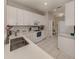 Bright kitchen featuring white cabinetry, modern appliances, and tile flooring at 595 Back Nine Dr, Venice, FL 34285