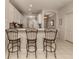 Kitchen bar featuring three barstools with decorative metal frame and light granite countertops at 595 Back Nine Dr, Venice, FL 34285