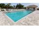 Community pool with a clear blue water, lounge chairs, and a building at 595 Back Nine Dr, Venice, FL 34285