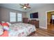 Bedroom with king-size bed, mounted TV, and adjacent bathroom at 600 Nasturtium Ct, Nokomis, FL 34275