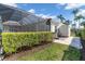 Well-maintained backyard with screened lanai, storage shed, and neat landscaping at 612 Cadiz Rd, Venice, FL 34285