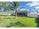 Expansive backyard featuring a well-manicured lawn, mature trees, and a screened-in pool area at 612 Cadiz Rd, Venice, FL 34285