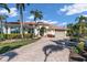 Charming home featuring lush landscaping, brick driveway, a three-car garage and a tile roof at 612 Cadiz Rd, Venice, FL 34285