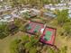 Aerial view showcasing tennis courts and community amenities amidst lush greenery and homes at 6462 Haele Ct, North Port, FL 34287