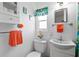 Bright bathroom features a pedestal sink, toilet, and decorative orange towels and washcloth at 6462 Haele Ct, North Port, FL 34287