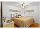 Comfortable bedroom with a queen-size bed, wooden floors, and a side table at 6462 Haele Ct, North Port, FL 34287