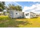 Exterior view of the home with a well-manicured lawn and lush trees at 6462 Haele Ct, North Port, FL 34287