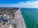 Expansive coastal view featuring a pristine beach, modern condo buildings, and a sparkling pool at 700 Golden Beach Blvd # 221, Venice, FL 34285