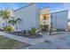 Exterior view of a coastal condo complex entrance with well-maintained landscaping at 700 Golden Beach Blvd # 221, Venice, FL 34285