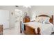 Bright bedroom with a wooden bed frame, soft pillows and view into the bathroom at 7145 Lakeside Dr, Sarasota, FL 34243