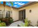 A bright villa entrance featuring a screen door, lovely plants, and a charming exterior light fixture at 7145 Lakeside Dr, Sarasota, FL 34243