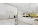 Modern kitchen with stainless steel appliances and bright white cabinetry with a view to the living room at 7145 Lakeside Dr, Sarasota, FL 34243