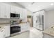 Modern kitchen with stainless steel appliances and bright white cabinetry and a view to the patio at 7145 Lakeside Dr, Sarasota, FL 34243